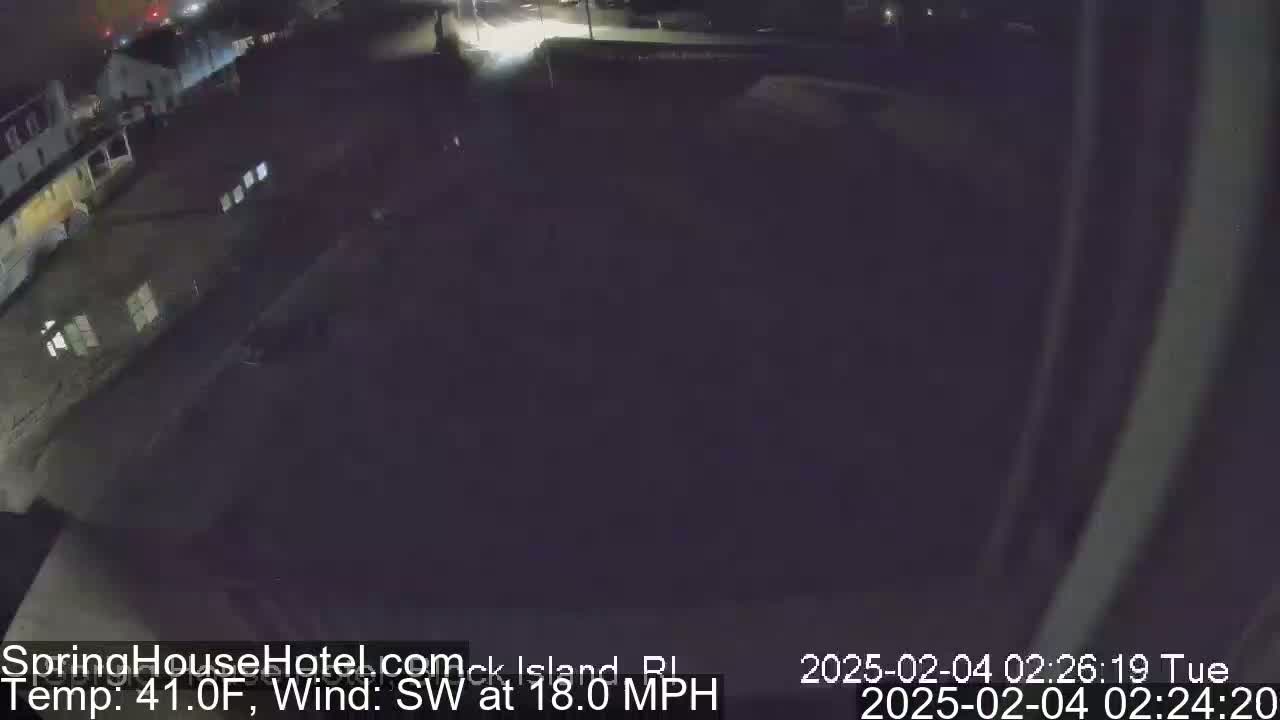 A nighttime, overhead view of a mostly empty parking lot and buildings with a southwest wind at 18 mph and a temperature of 41°F.