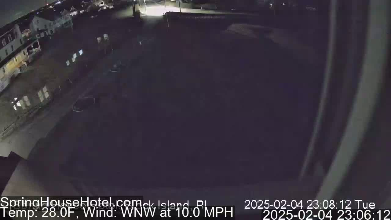 A nighttime, low-angle, outdoor view of a parking lot and buildings with a 28°F temperature and a 10 mph wind from the west-northwest.