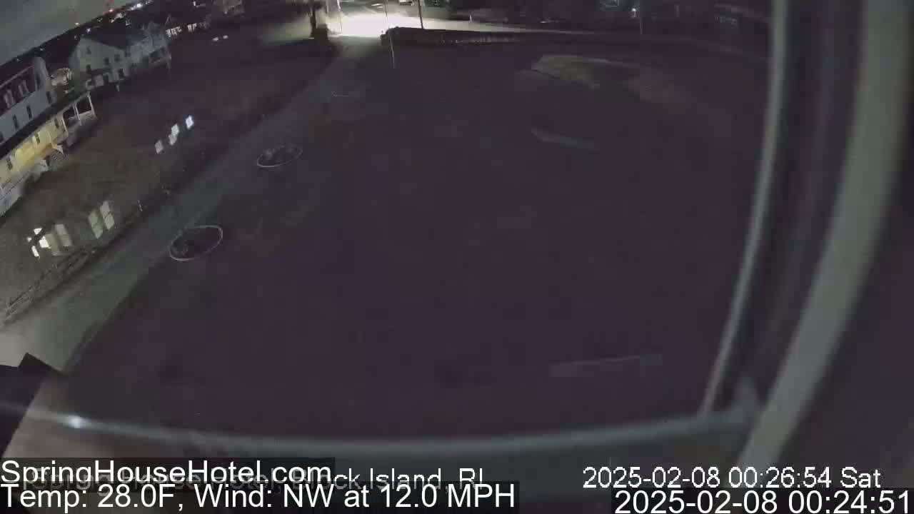 A nighttime, low-angle view of a dark street and building, with a northwest wind at 12 mph and a temperature of 28 degrees Fahrenheit.