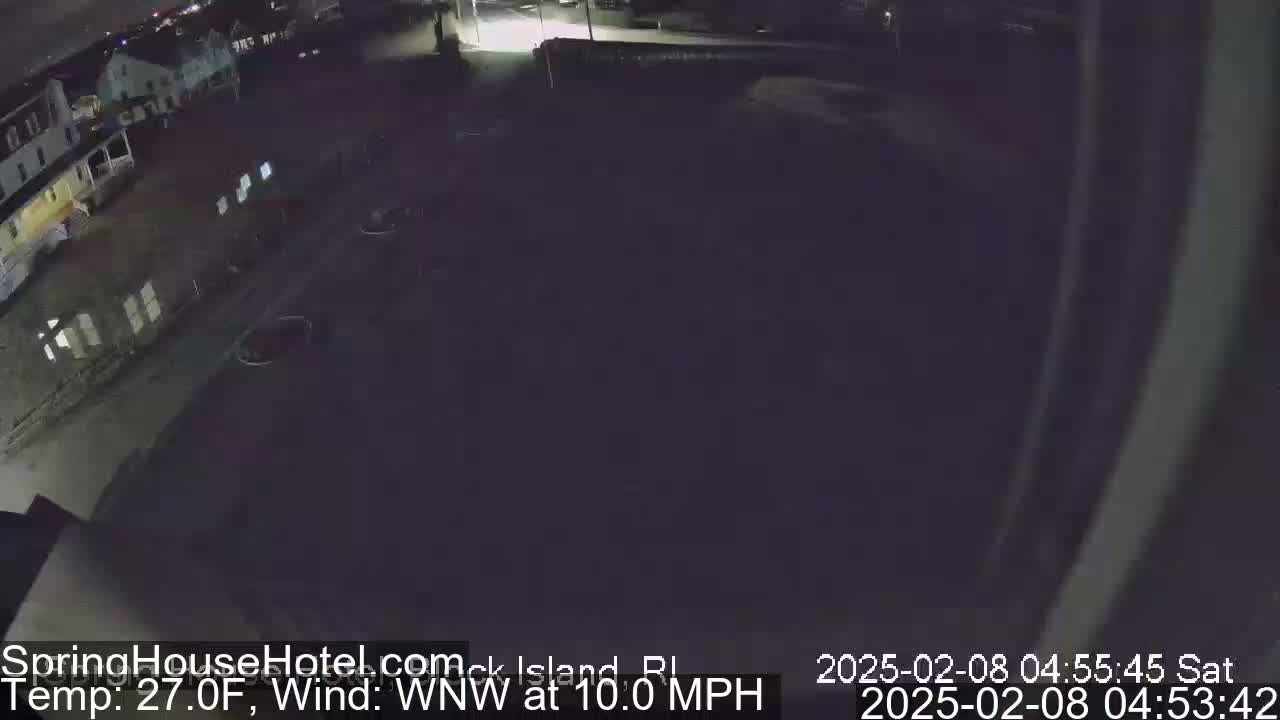 A nighttime, low-angle view of a parking lot and buildings, with a WNW wind at 10 mph and a temperature of 27°F.