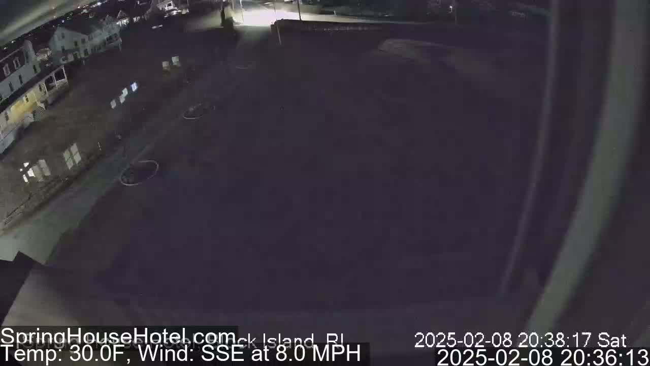 A nighttime, overhead view of a dark parking lot and a building, with an 8 mph wind blowing from the south-southeast at 30°F.