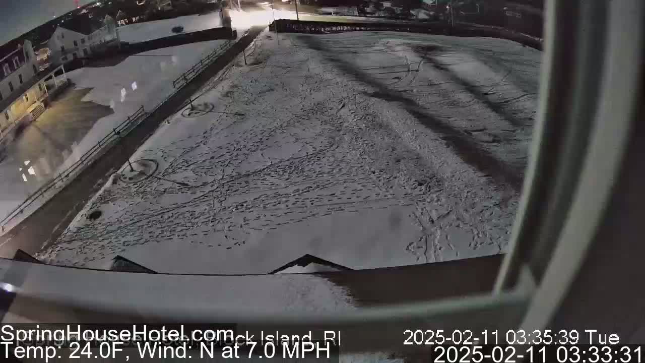 A snow-covered area with numerous footprints is visible at night, illuminated by artificial light.