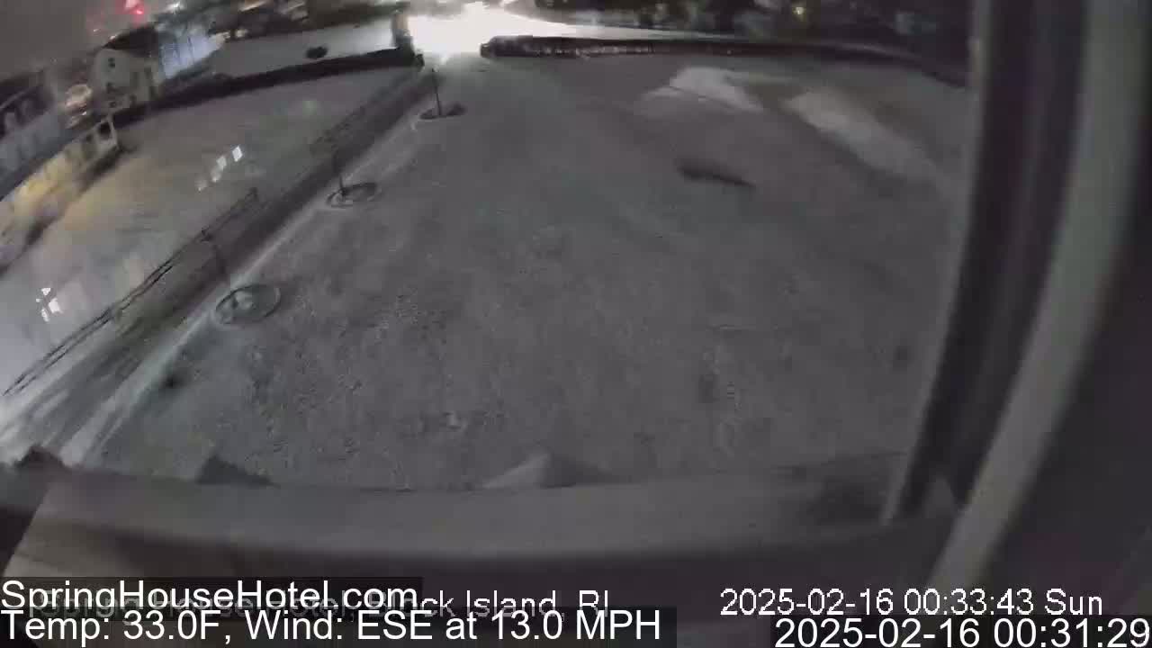 A snow-covered parking lot is seen at night with a 33°F temperature and a 13 mph wind from the east-southeast.