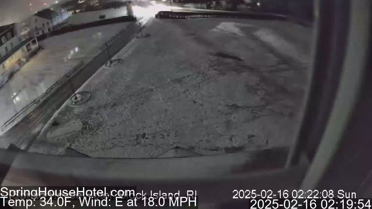 A snow-covered parking lot is visible at night, with an easterly wind blowing at 18 mph and the temperature at 34°F.