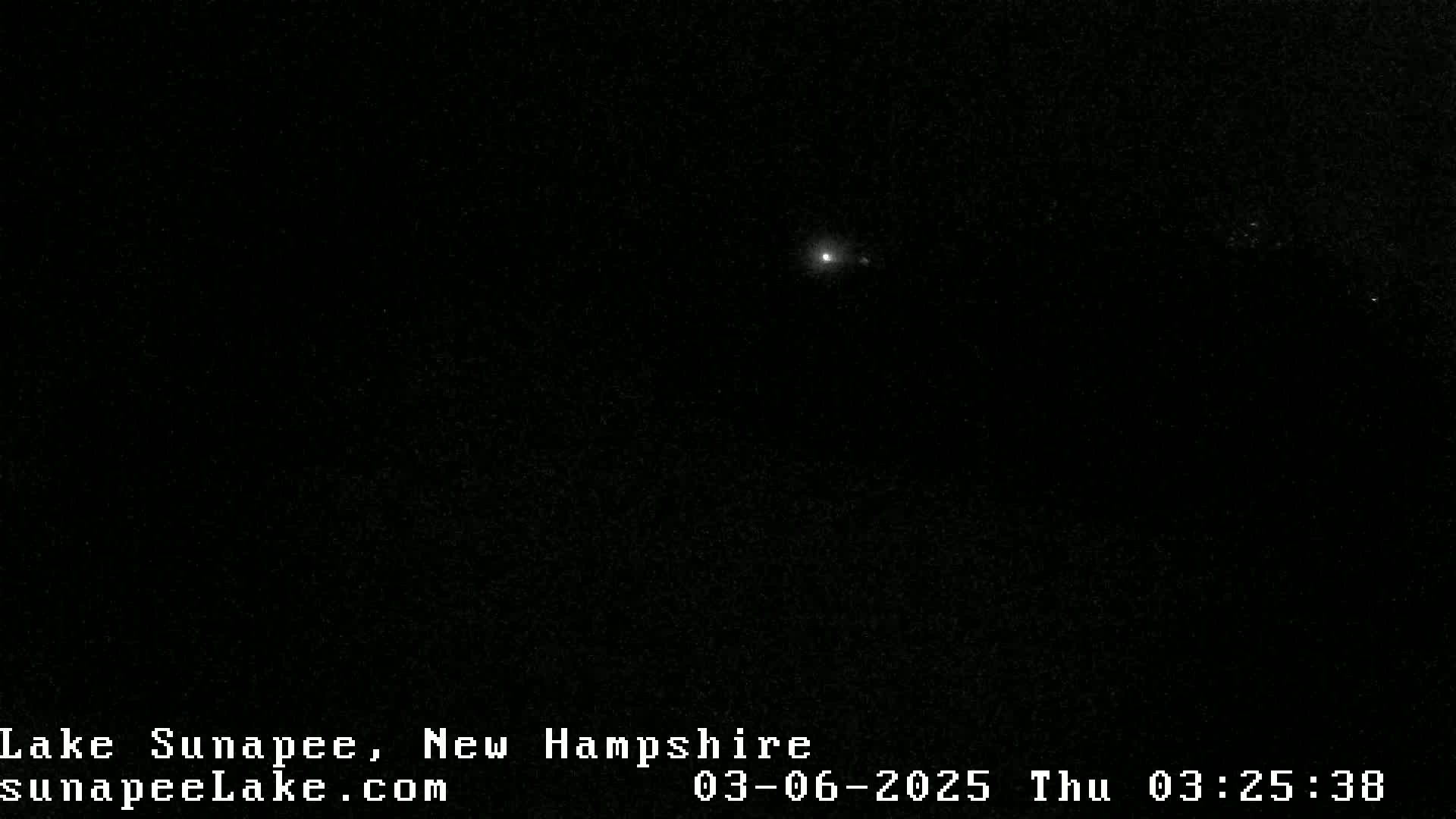 A single, bright point of light is visible in a dark, nighttime sky.