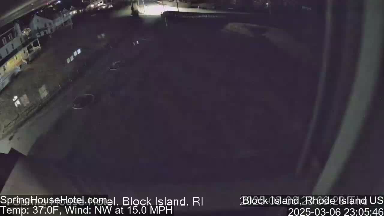 A nighttime, high-angle view of a dark parking lot and buildings with a northwest wind at 15 mph and a temperature of 37°F.