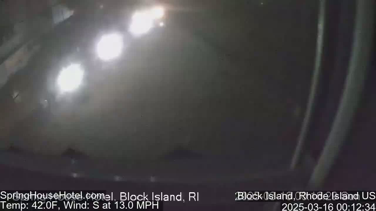 A nighttime, hazy outdoor scene shows bright headlights from vehicles in the distance, with a south wind at 13 mph and a temperature of 42°F.