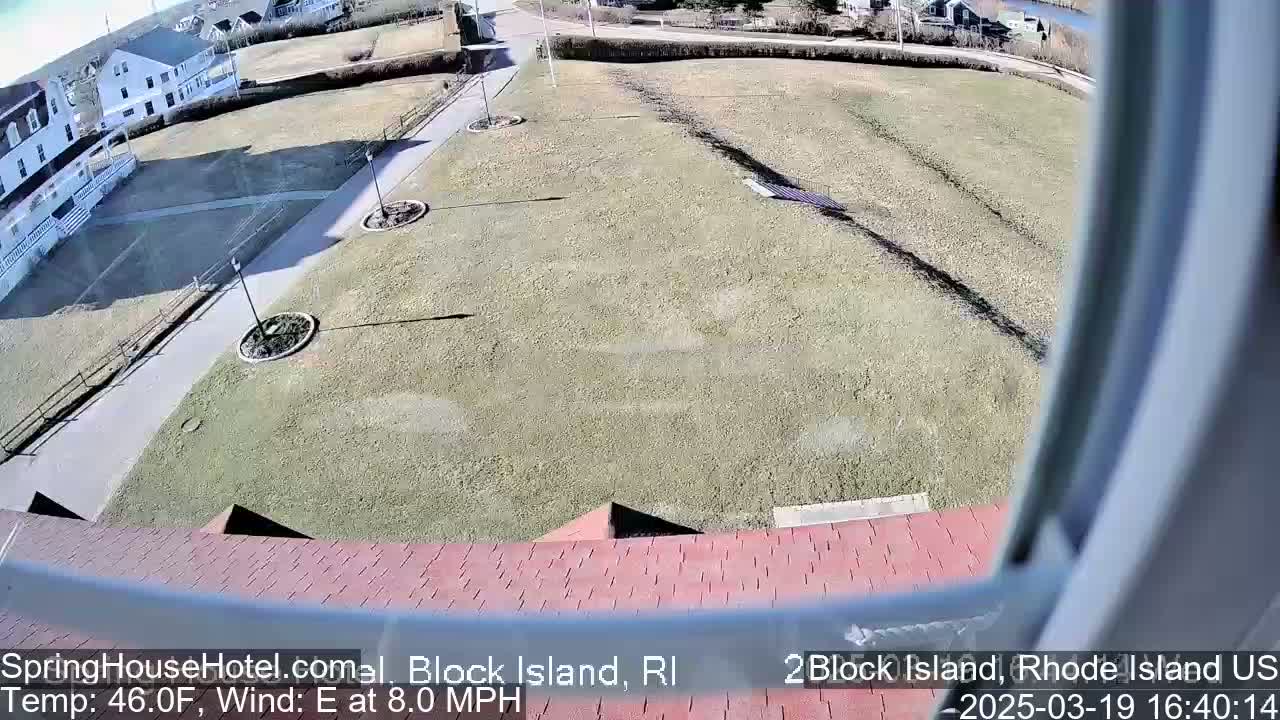 A high-angle view of a grassy area, a walkway, and a building on a sunny day with an east wind at 8.0 mph and a temperature of 46°F.