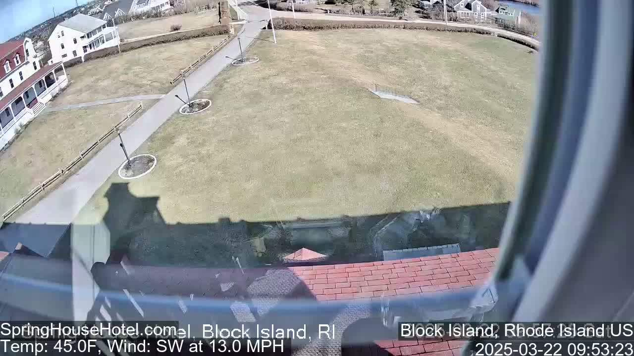 A high-angle view shows a grassy area with a paved walkway, buildings in the background, under sunny skies with a southwest wind at 13 mph and a temperature of 45°F.