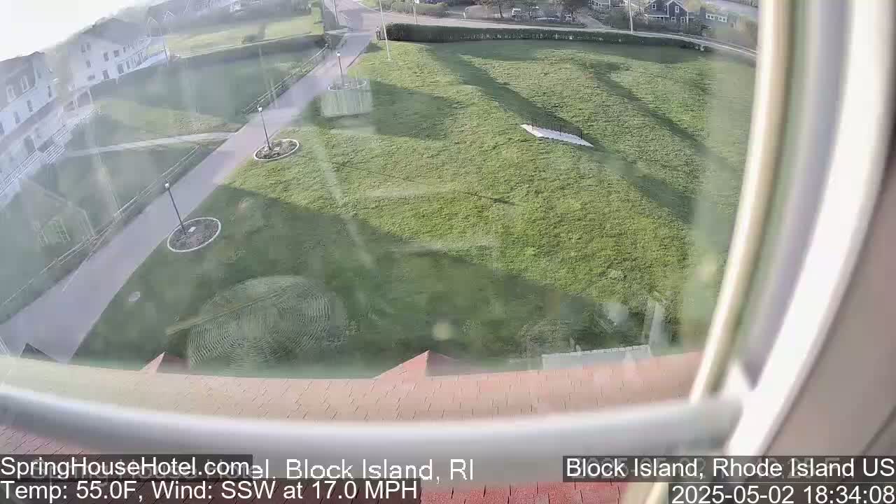 A view from a window shows a grassy area with walkways and buildings in the background, under slightly hazy conditions with a south-southwesterly wind.