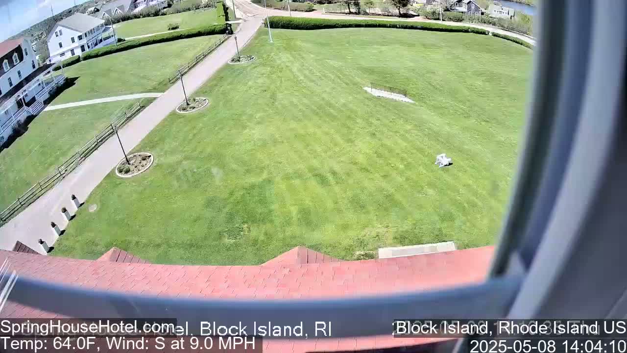 A high-angle view shows a large grassy area with a building and pathways, on a sunny day with a south wind at 9 mph.