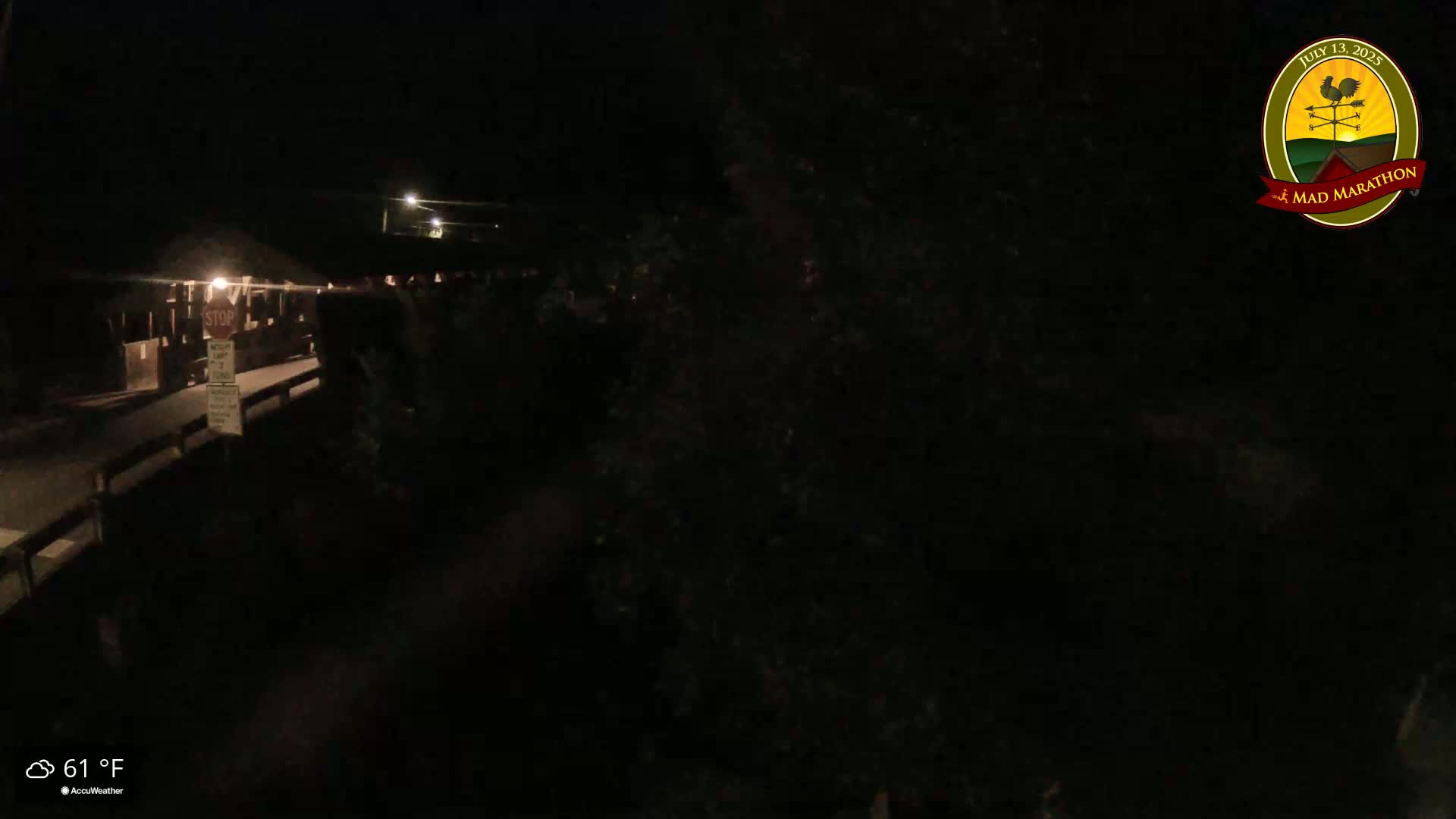 A nighttime, low-light view of a dark roadway and building, with a temperature of 61°F.