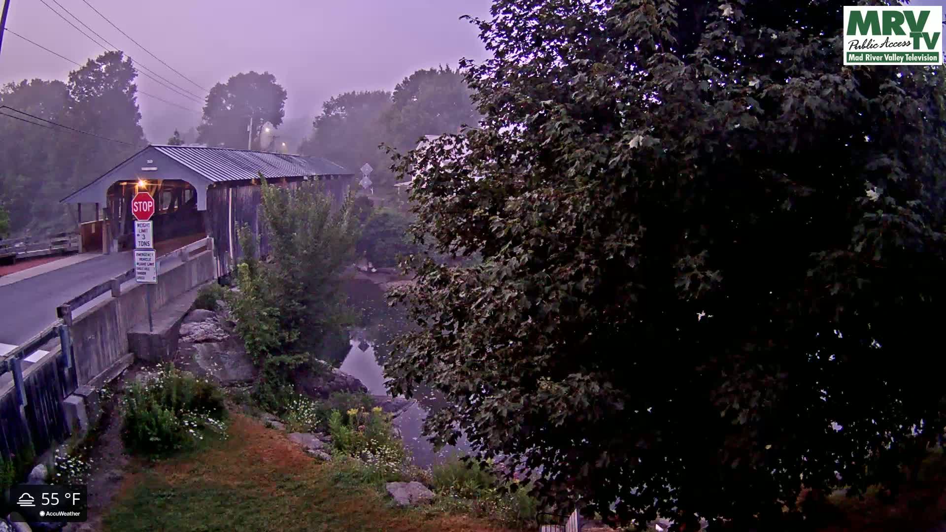 A nighttime, low-light view of a bridge with a stop sign and dimly lit surroundings, at 71°F.