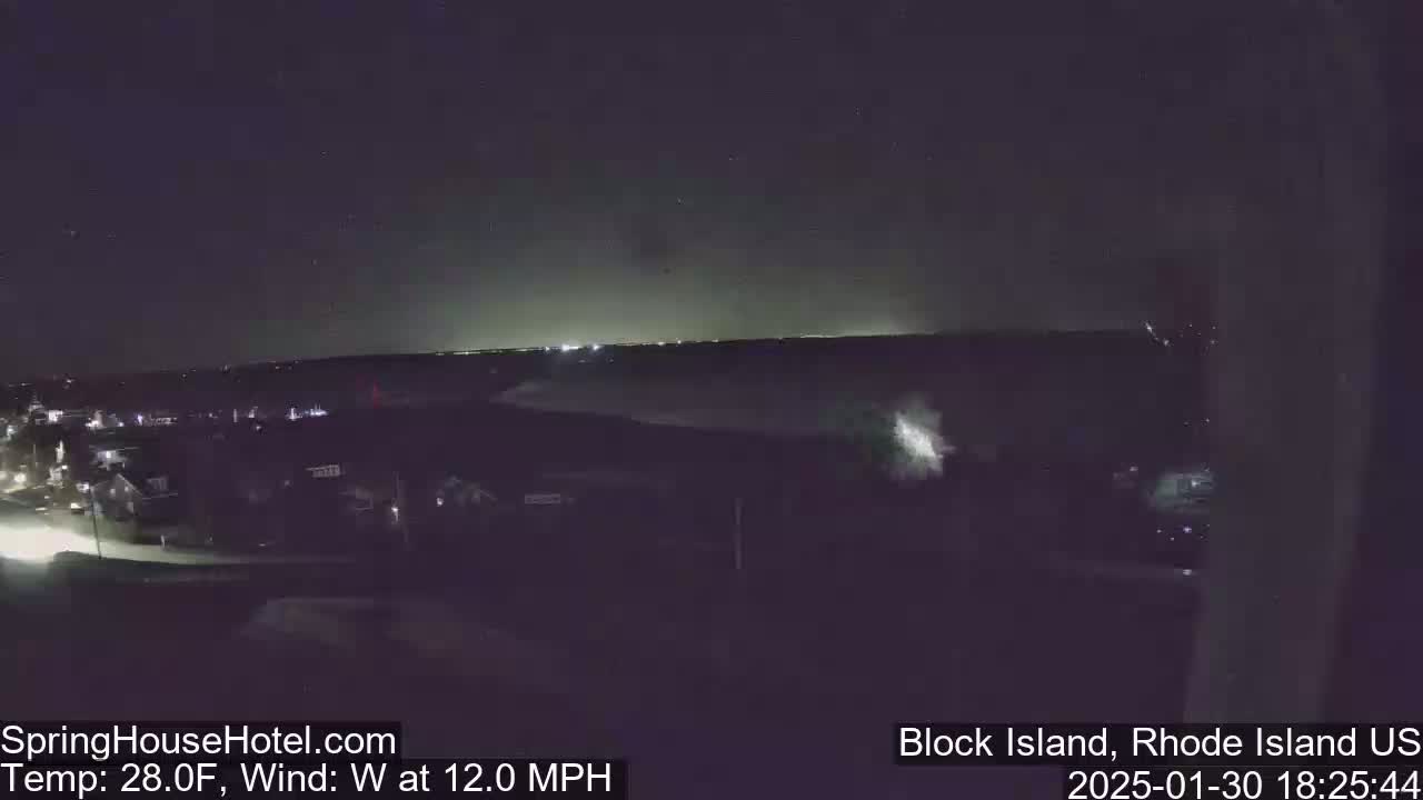 A nighttime view of a town with a slightly hazy sky and a 12 mph west wind at 28°F.