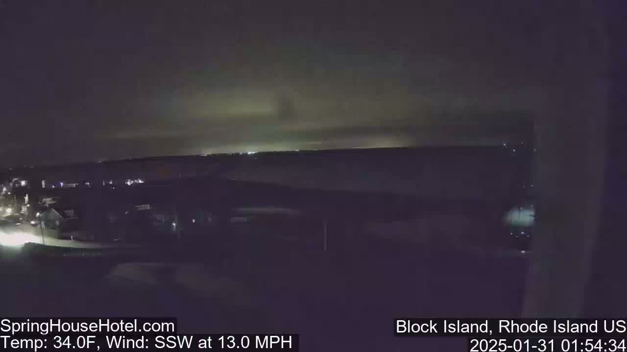 A nighttime, high-angle view of a residential area with a 34°F temperature and a 13 mph south-southwest wind.
