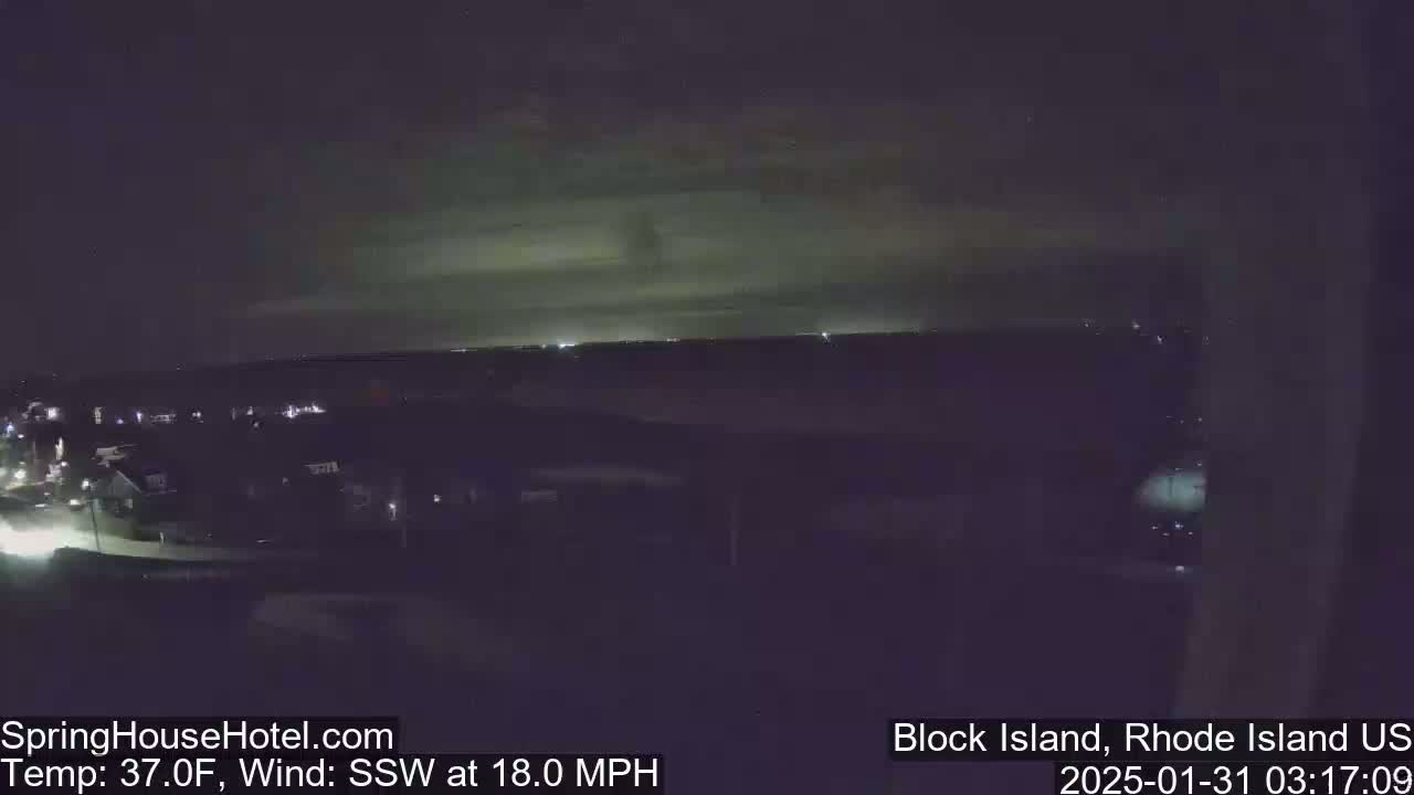 A nighttime, long shot of a town with a cloudy sky and an 18 mph wind from the southwest.