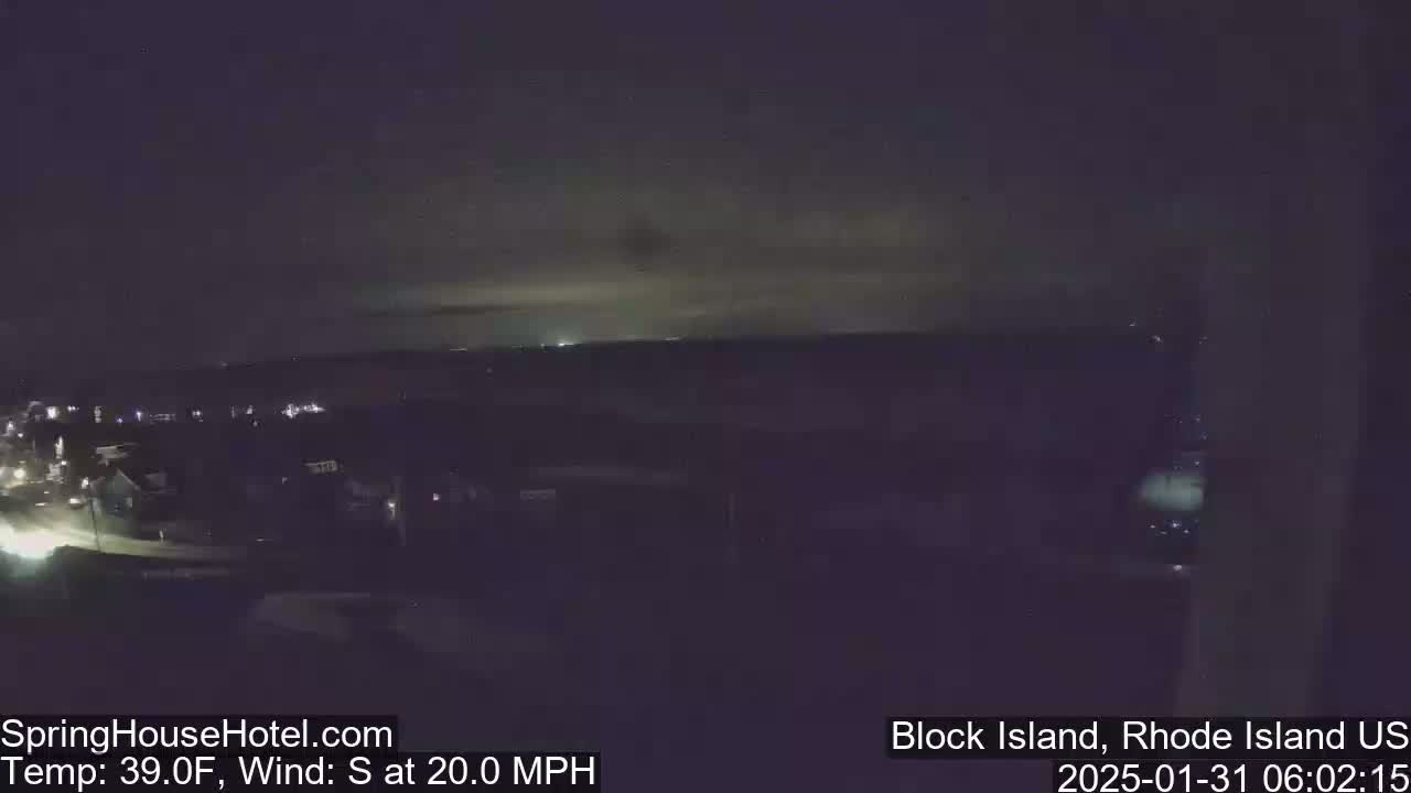 A nighttime, long shot of a town under a dark, cloudy sky with a 20 mph south wind and a temperature of 39°F.