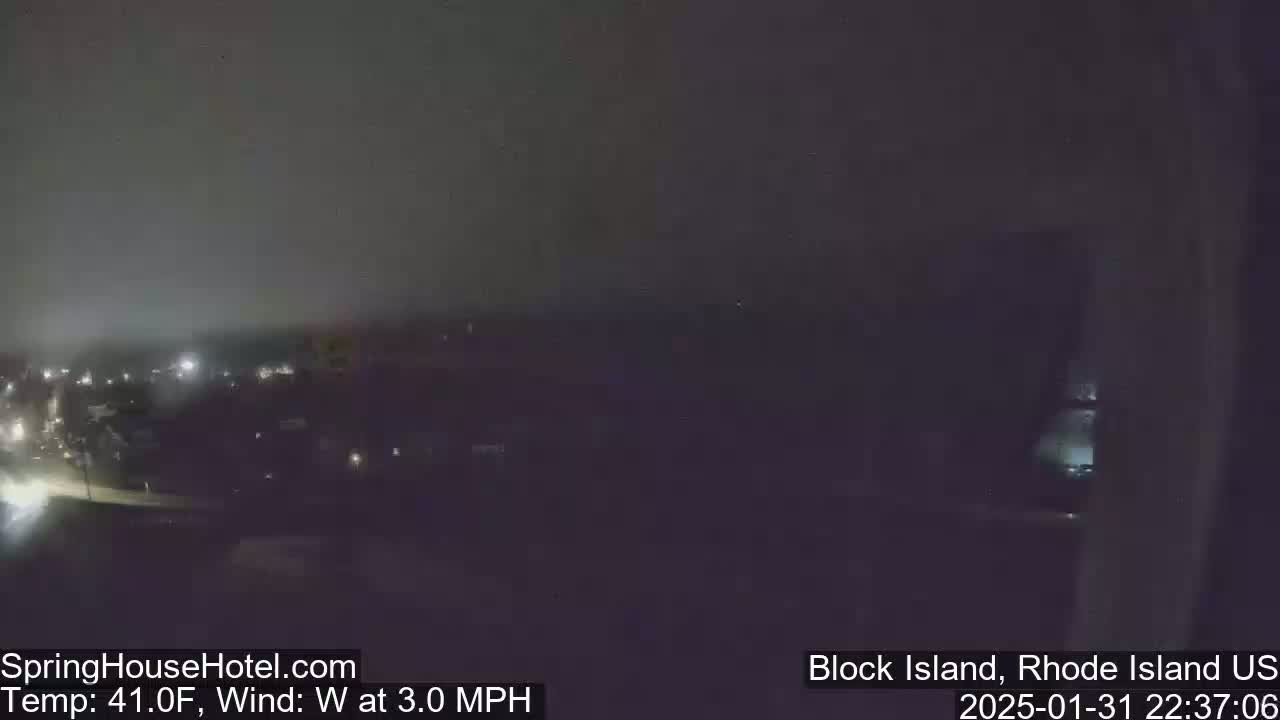 A nighttime view of dimly lit buildings and a road under a foggy, dark sky with a 3 mph westerly wind and a temperature of 41°F.
