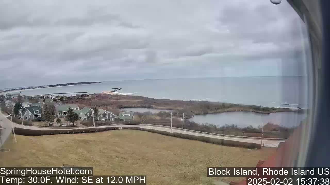 A coastal scene on an overcast day shows a body of water, houses, and marshland, with a southeastern wind blowing at 12 miles per hour and a temperature of 30 degrees Fahrenheit.