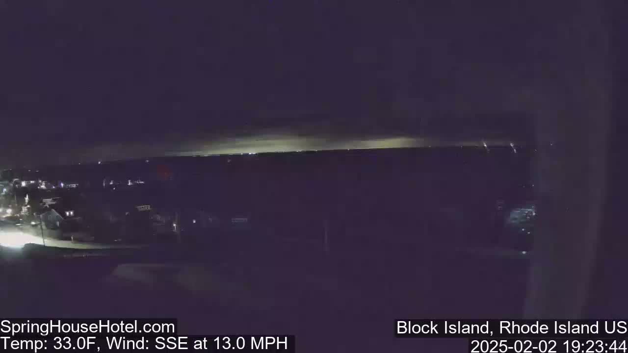 A nighttime, high-angle view shows a dark landscape with a faint horizon line of lights, under a dark sky with a SSE wind at 13 mph and a temperature of 33 degrees Fahrenheit.