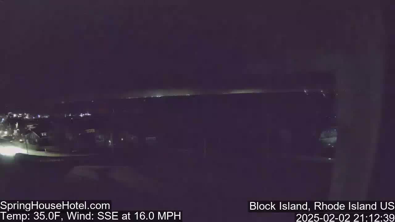 A nighttime, elevated view shows a dark residential area with a faintly lit horizon in the distance, under a dark sky with a 16 mph wind from the SSE and a temperature of 35 degrees Fahrenheit.