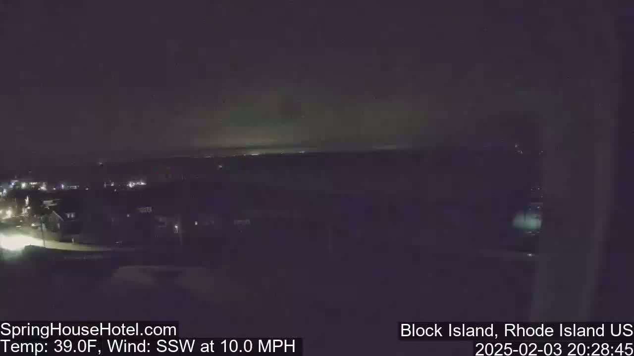 A nighttime, elevated view of a dimly lit town with a south-southwesterly wind at 10 mph and a temperature of 39 degrees Fahrenheit.