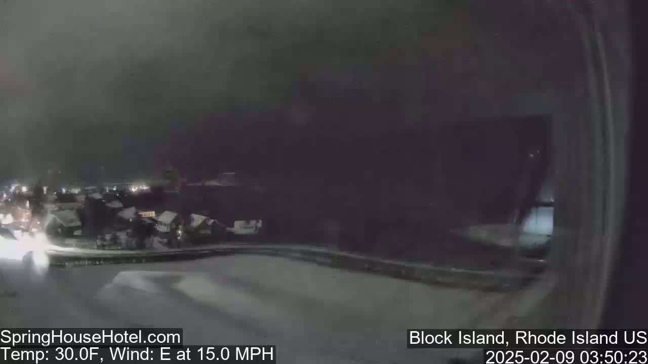 A nighttime, snowy scene shows a dimly lit town with a 30°F temperature and 15 mph east wind.
