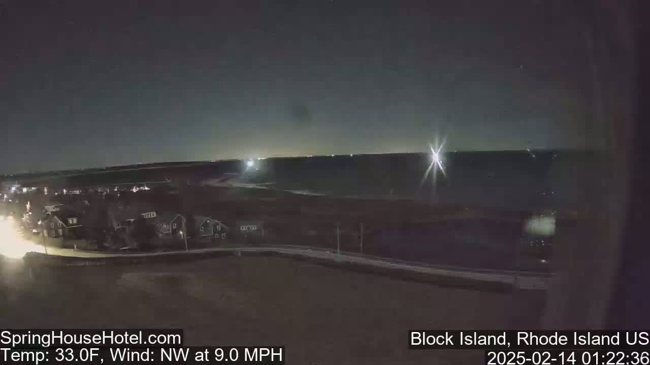A nighttime, wide shot of a coastal town with a clear sky and a northwest wind blowing at 9.0 mph; the temperature is 33 degrees Fahrenheit.