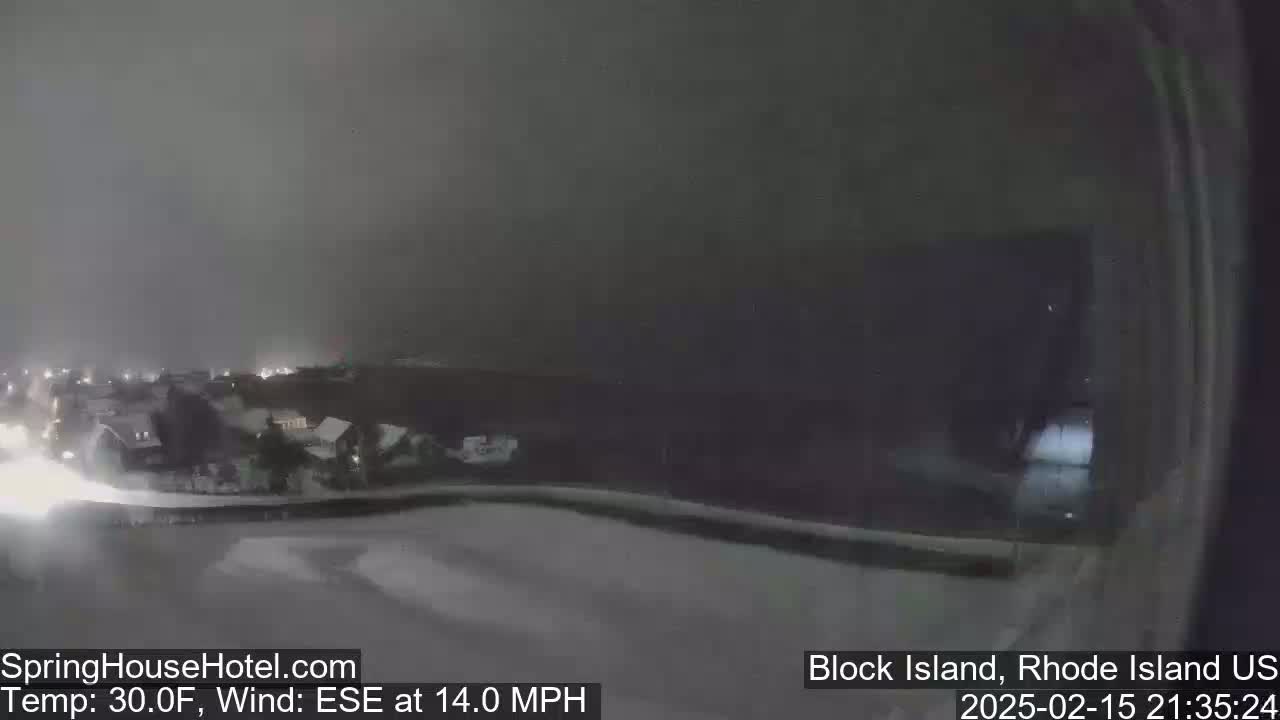A nighttime, snowy scene shows a lightly snow-covered town with a 14-mph wind blowing from the east-southeast at 30°F.