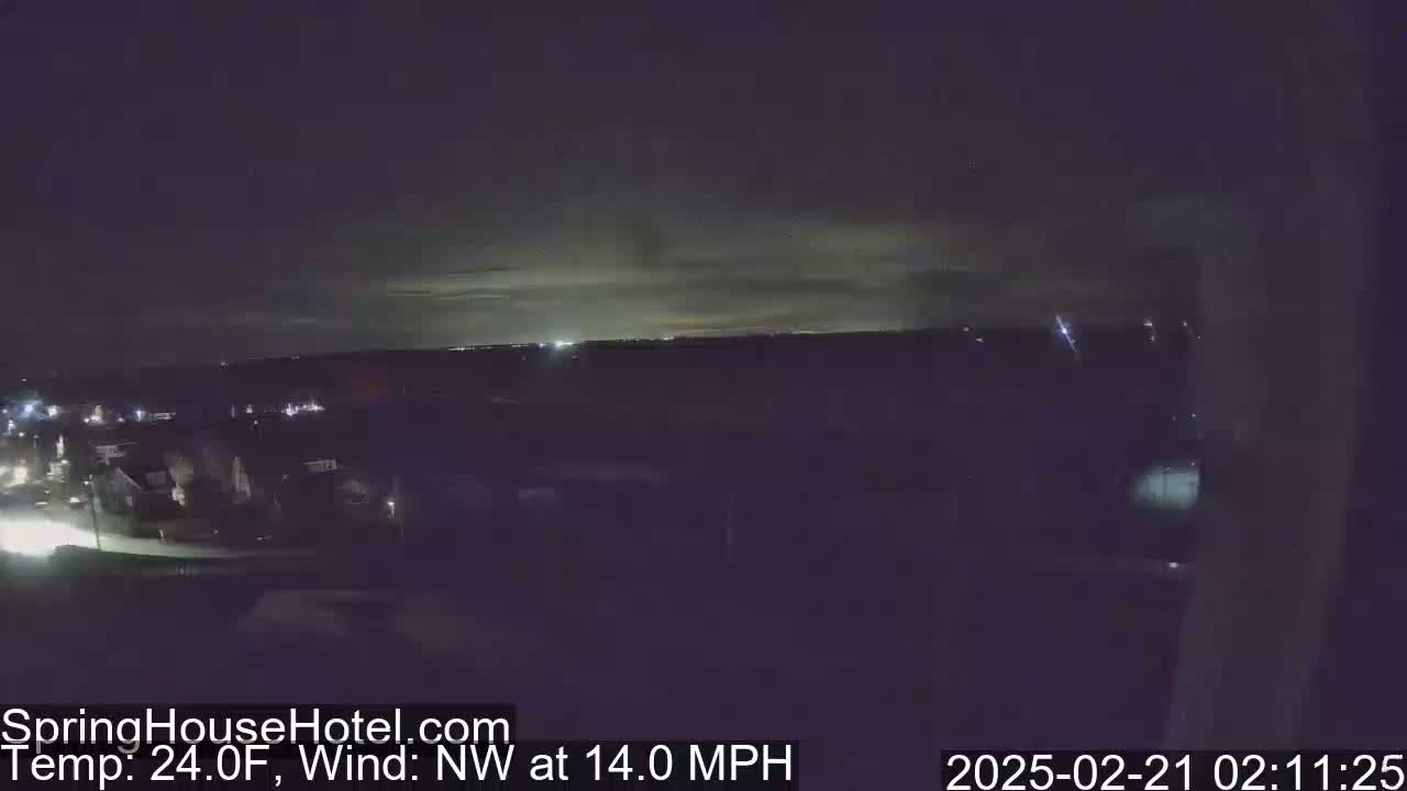 A nighttime view of a suburban area under a dark sky with a faint, light horizon, with a northwest wind at 14 mph and a temperature of 24 degrees Fahrenheit.