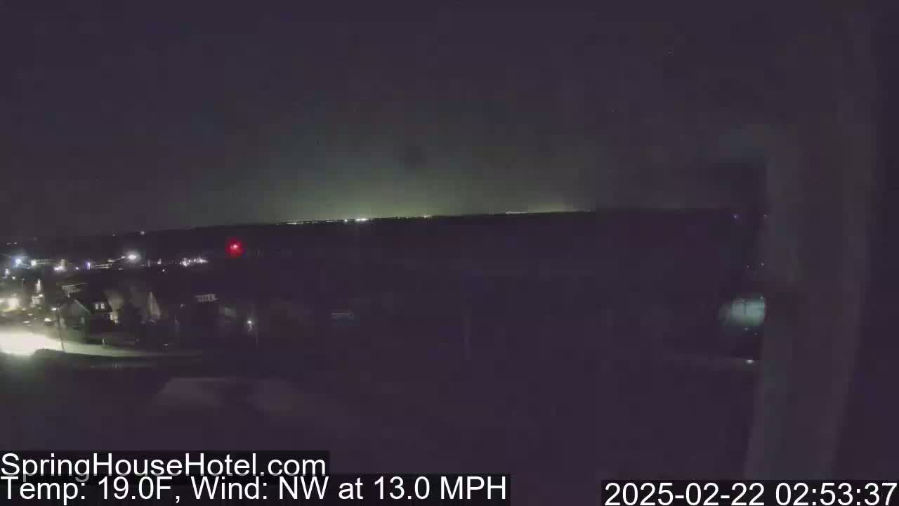 A nighttime, long shot of a residential area with a northwest wind at 13 mph and a temperature of 19 degrees Fahrenheit.