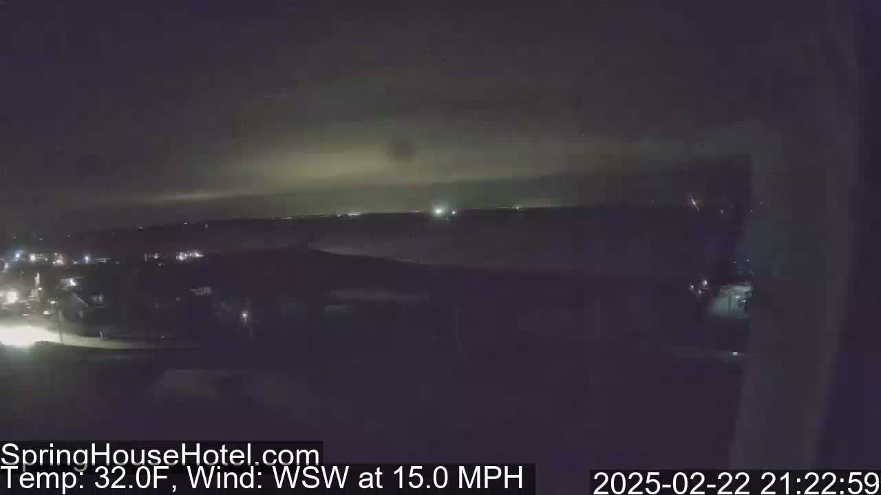 A nighttime, high-angle view of a suburban area with a WSW wind at 15 mph and a temperature of 32°F.