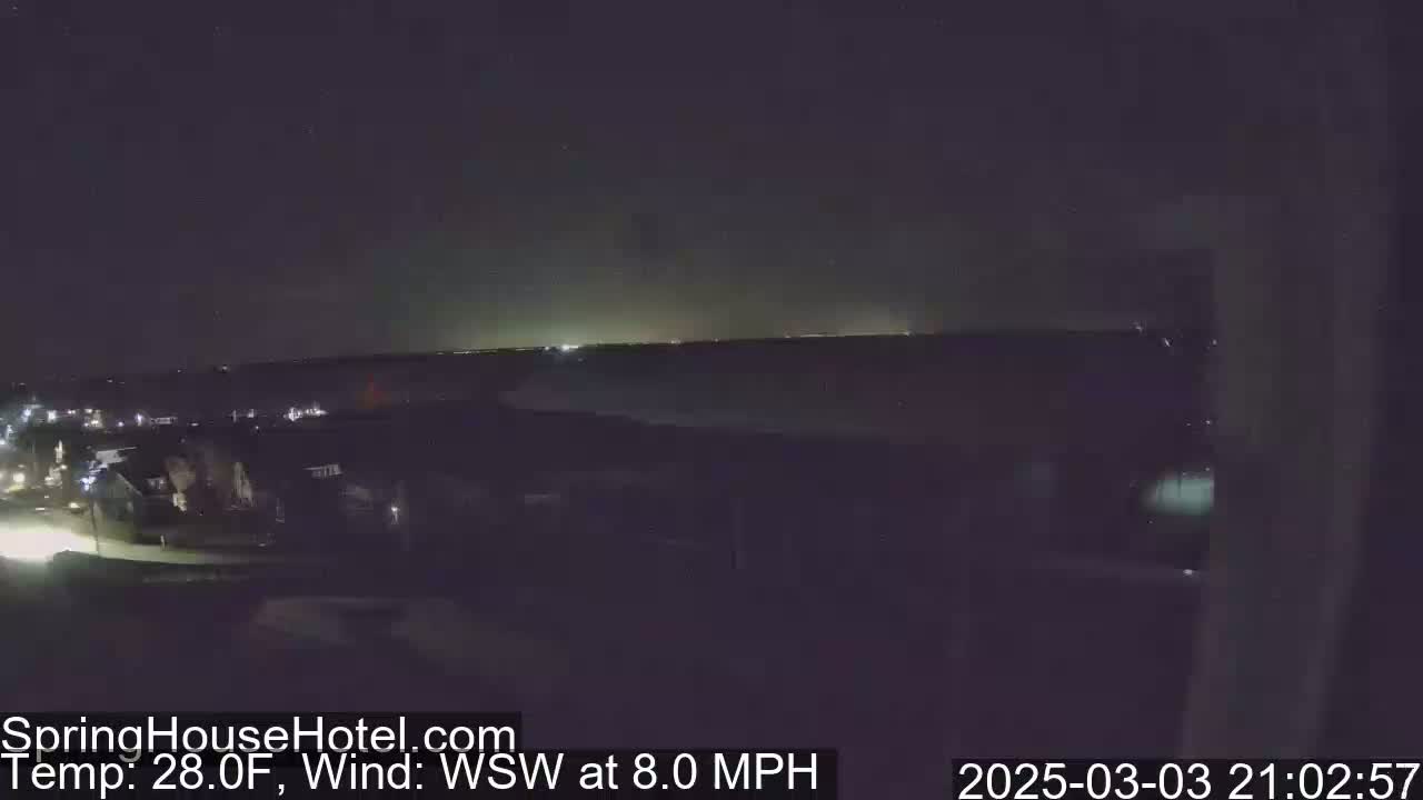 A nighttime view of a residential area near a body of water under a clear, dark sky with a WSW wind at 8.0 mph and a temperature of 28.0°F.