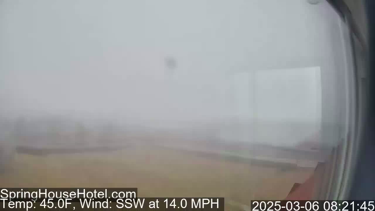 A foggy, outdoor scene shows a flat, tan landscape under a hazy sky with a 14 mph wind from the south-southwest.