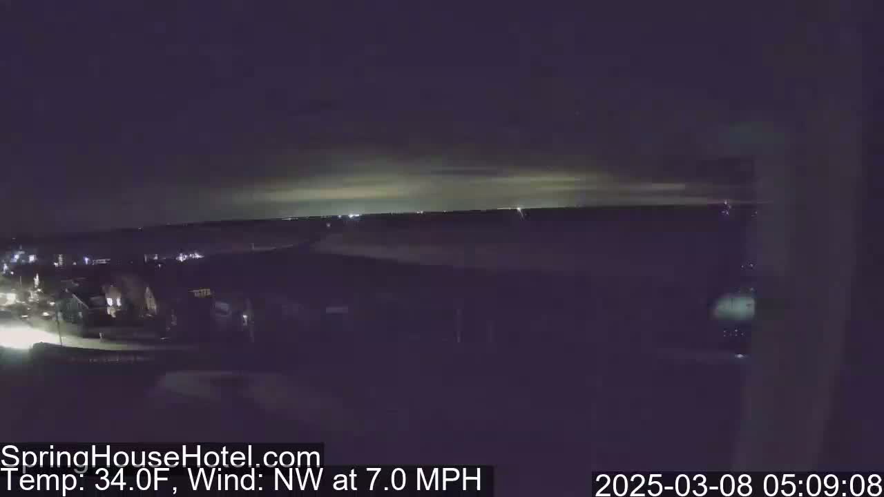 A nighttime, long shot of a suburban area with a northwest wind at 7.0 mph and a temperature of 34 degrees Fahrenheit.