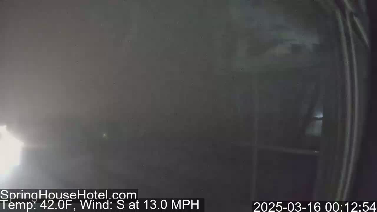 A hazy, outdoor scene shows a blurry view of a building's exterior with a 42°F temperature and a 13 mph south wind.