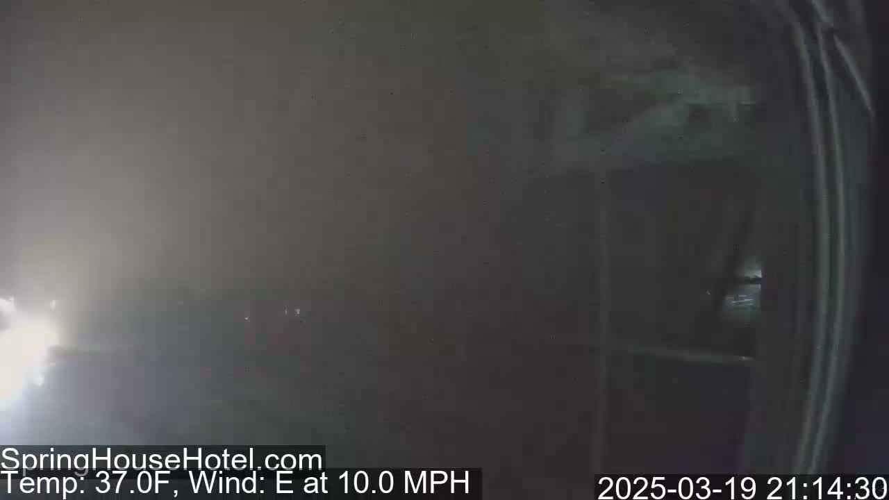A foggy outdoor scene at night shows a building with windows, with an easterly wind blowing at 10 mph and a temperature of 37°F.