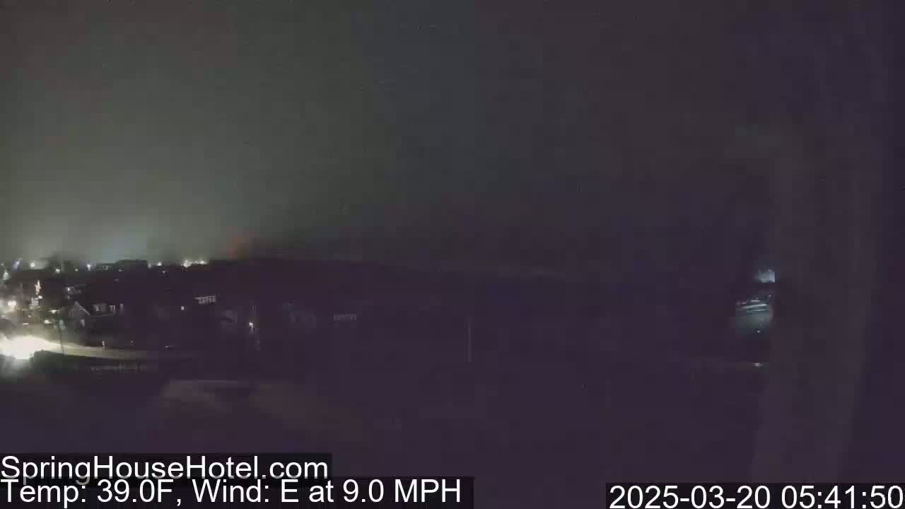 A nighttime view of a residential area under a hazy, dark sky with an east wind blowing at 9.0 mph and a temperature of 39°F.