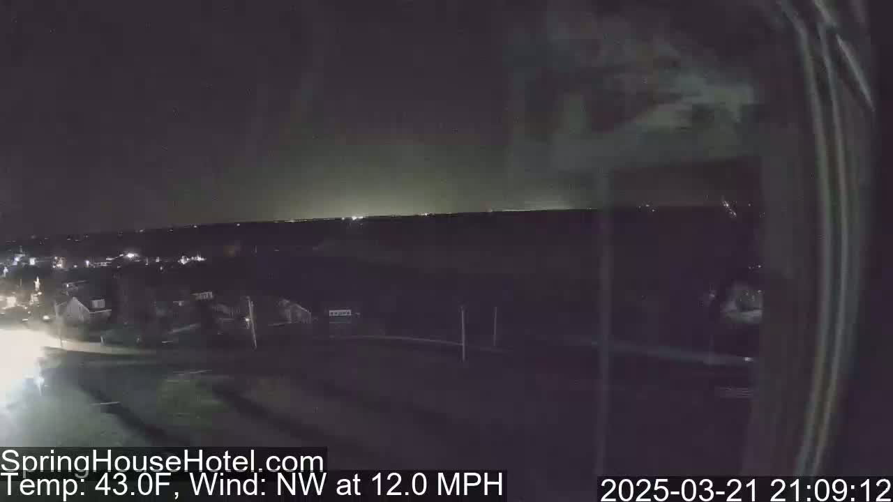 A nighttime view of a residential area under a dark sky with a northwest wind at 12 mph and a temperature of 43 degrees Fahrenheit.