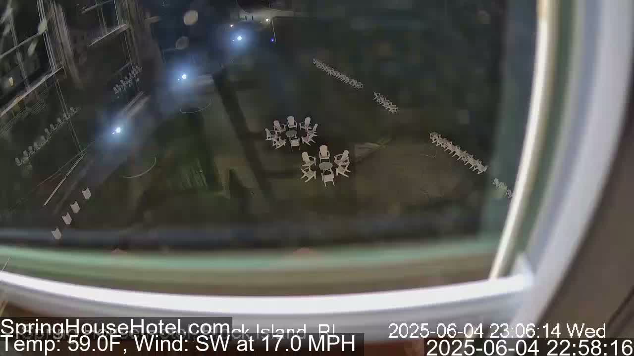 A nighttime, high-angle view shows an outdoor patio area with several small groups of white chairs and tables, under a southwest wind blowing at 17 mph and a temperature of 59°F.