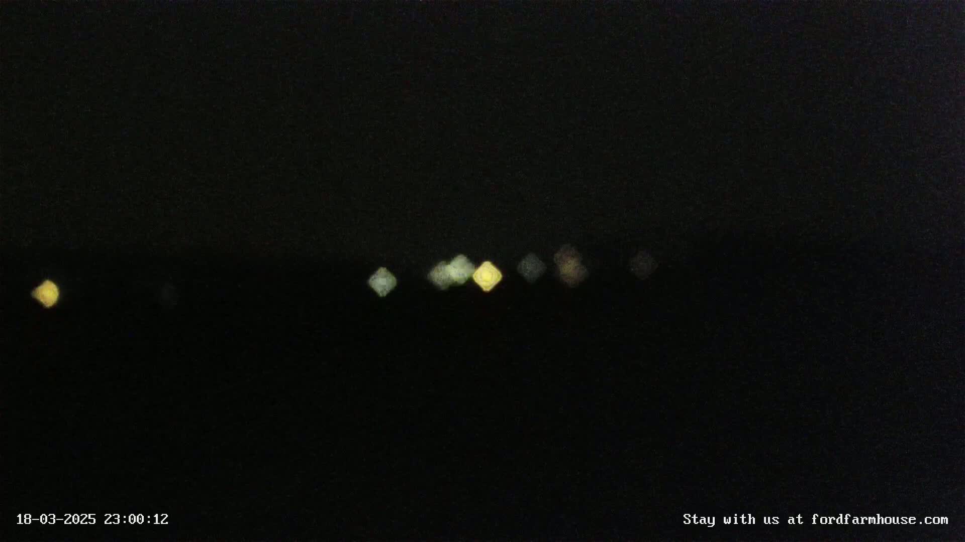 A nighttime, blurry view of several out-of-focus lights in the distance.