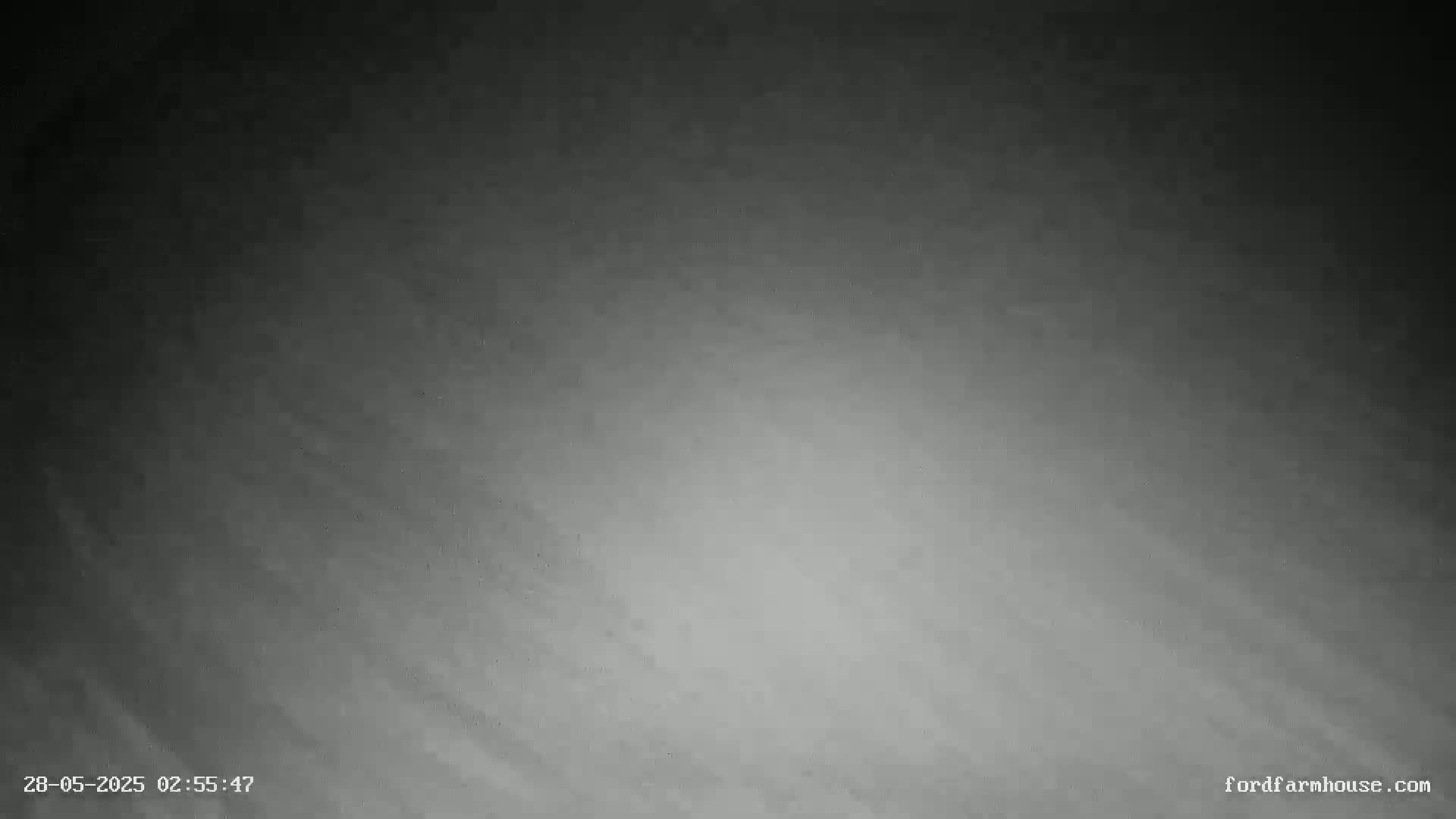 A grayscale image shows a dark, cloudy night sky.