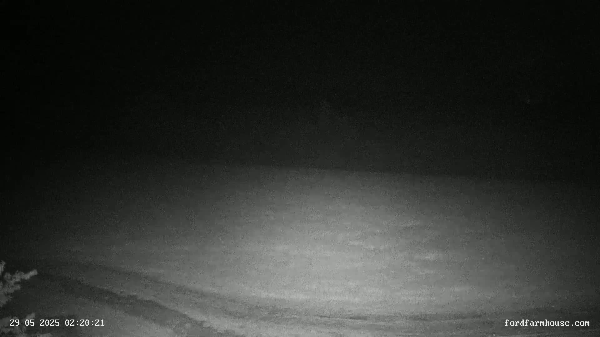A dark, nighttime outdoor scene shows a mostly flat expanse of ground under a black sky.