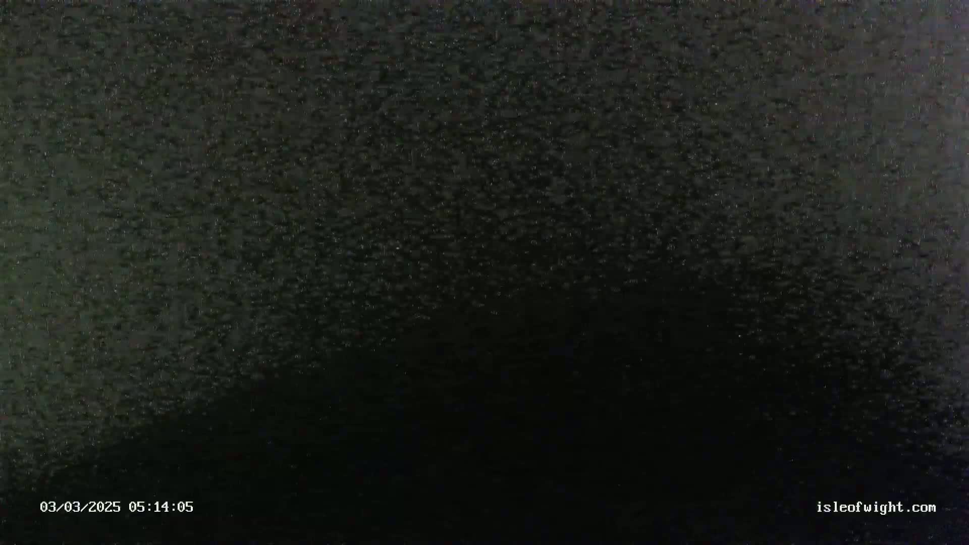 A dark, nighttime scene of heavy rain.