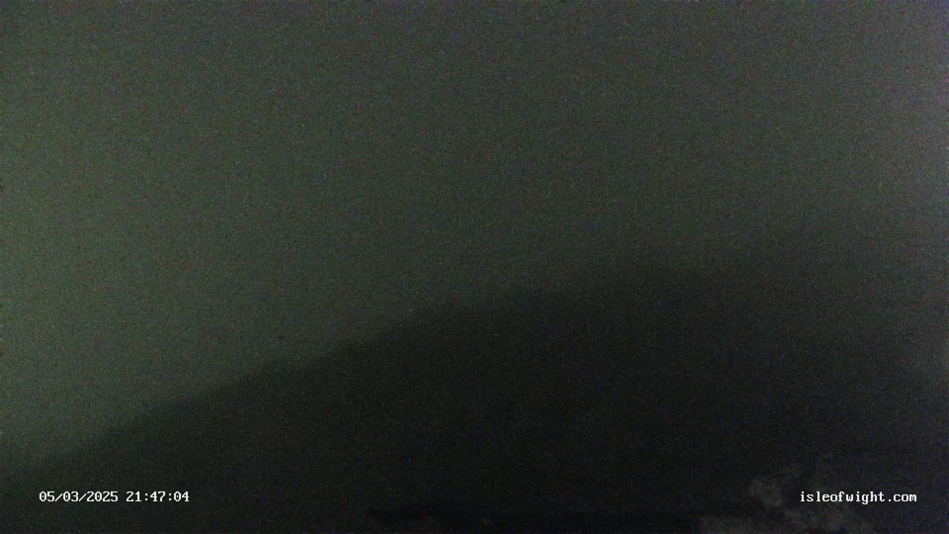 A dark, nighttime image shows a mostly featureless, dark gray sky.