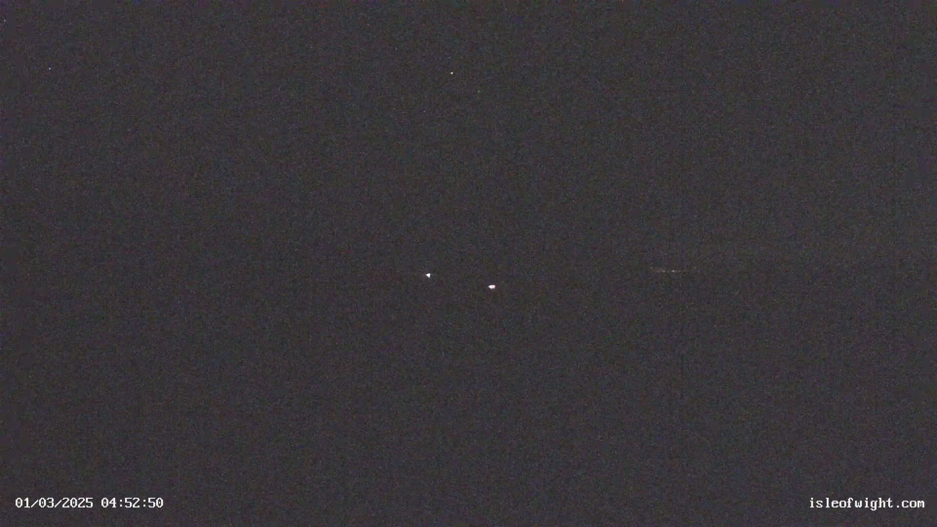 A nighttime image shows two bright lights in the dark sky.