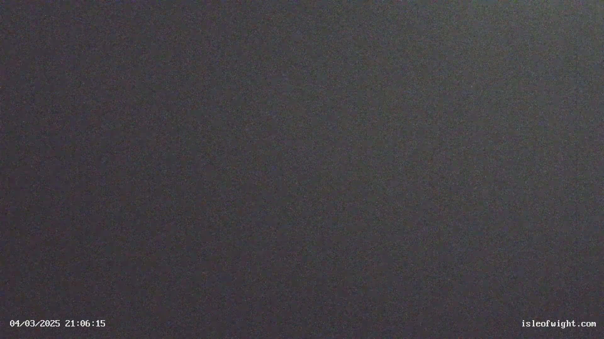 A dark gray, possibly nighttime image shows a uniformly textured surface.