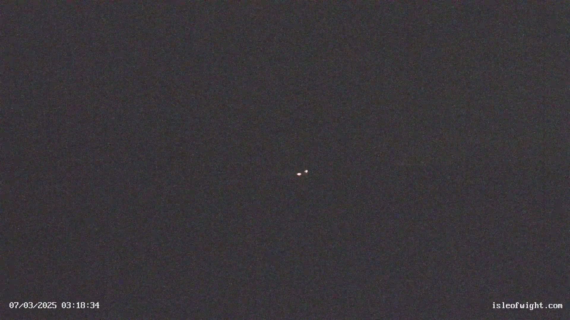 A dark night sky shows two faint, distant lights.