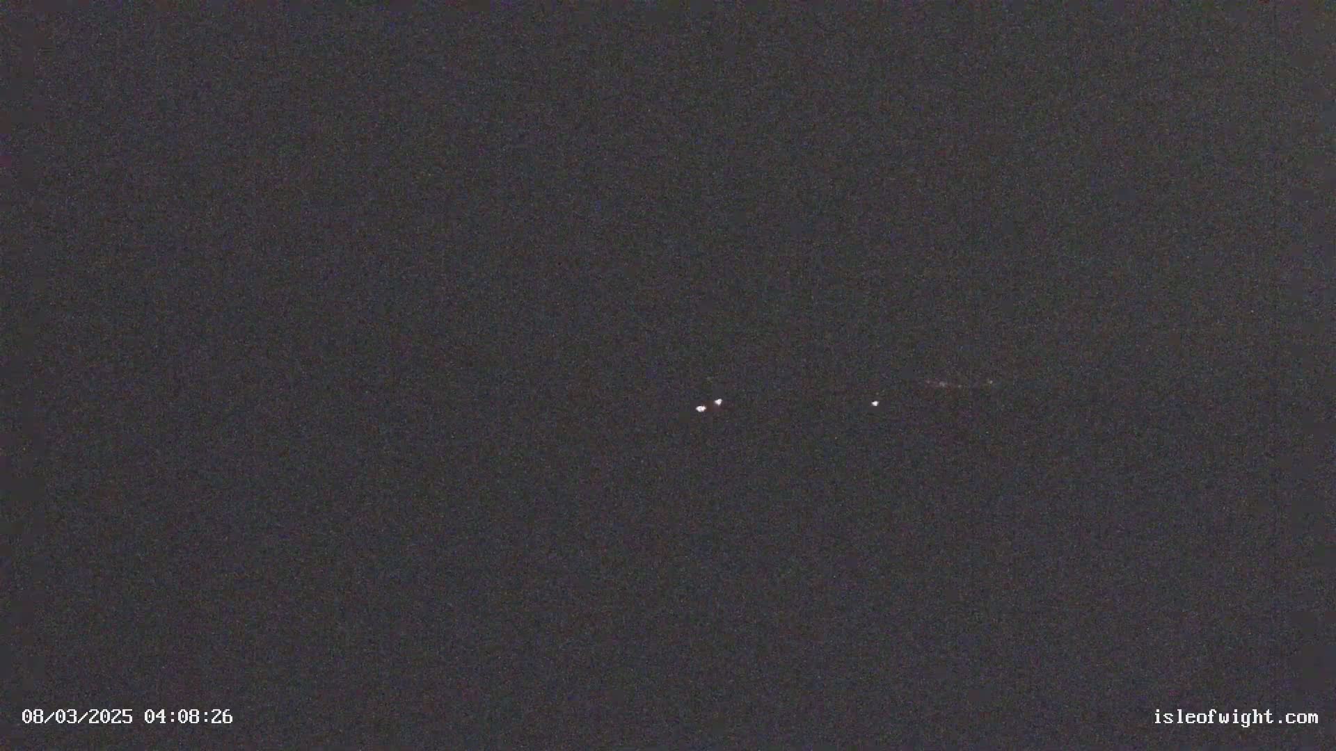 Three faint lights are visible in the dark night sky.