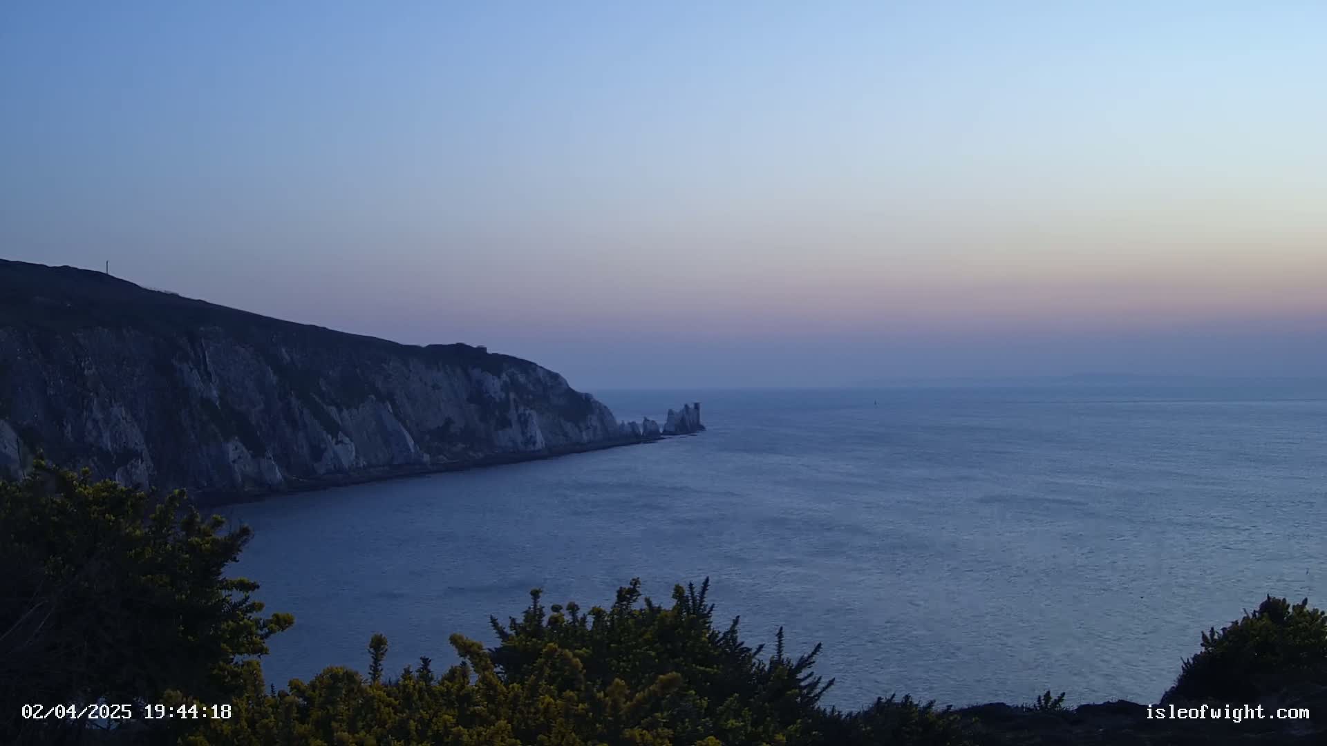 White cliffs meet a calm, twilight sea.